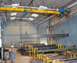 EPDE suspension cranes with rolled-profile girders and two DC-Pro chain hoists operating in tandem for handling long material in a store