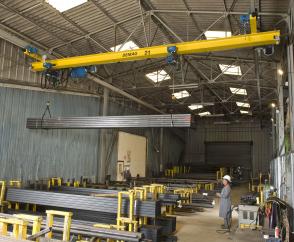 EPDE suspension cranes with rolled-profile girders and two DC-Pro chain hoists operating in tandem for handling long material in a store