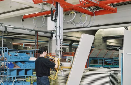 Production of office furniture: double-girder suspension crane with a vacuum spreader to pick up and turn coated particle board through 90 degrees