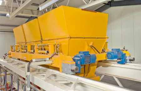 Rugged travel application in a dusty environment: Demag offset geared motors with wheel blocks for distribution carriages fitted with integrated weighing devices in a cement plant.