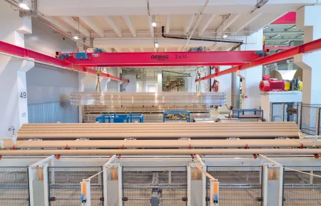 Overhead travelling crane with two hoist units for handling bundles of paper cores