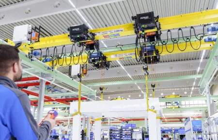 Ein Bedienender steuert einen Kran mit vier Demag Seilzügen DHR per Funksteuerung.