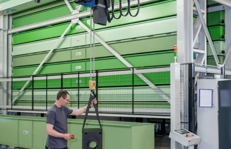 Work situation with Demag chain hoist and Demag KBK light crane system in the background.